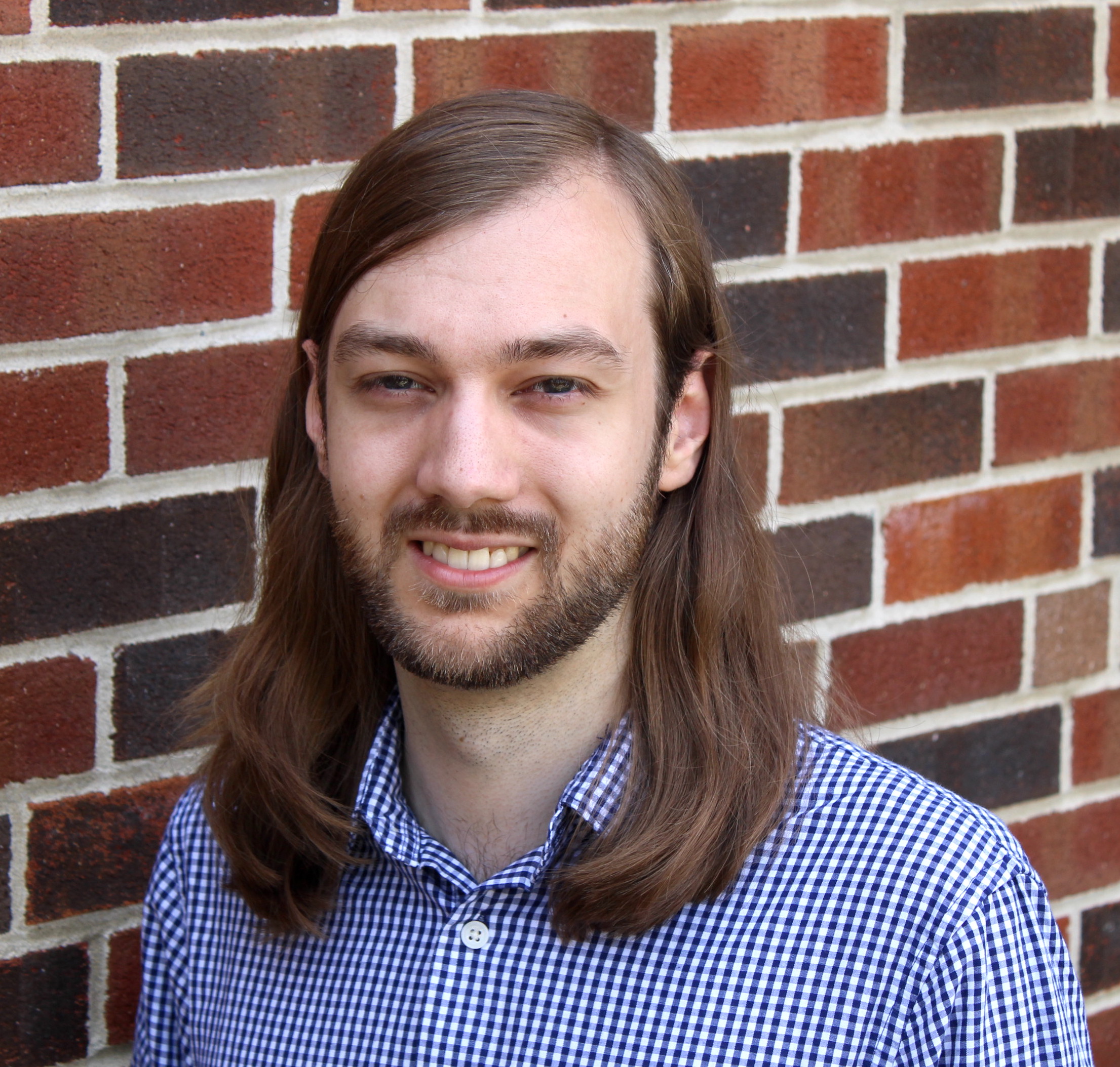 Male with plaid shirt smiling headshot